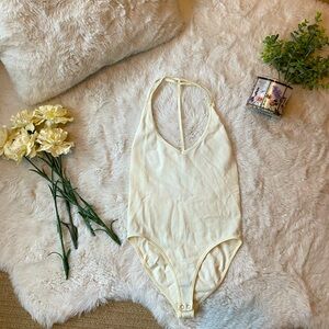 White low cut low back body suit.